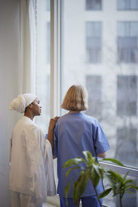Female doctors standing and talking at hospital corridor