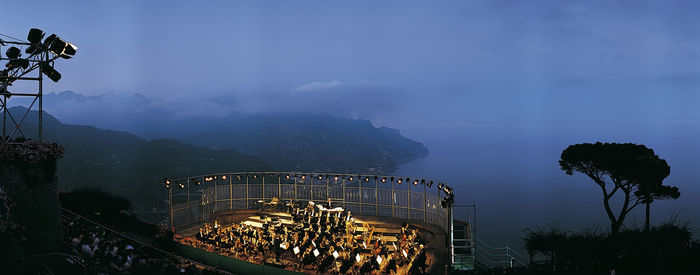 Panoramic view of illuminated mountains against sky at night