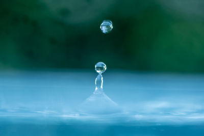 Close-up of water drop against blue sky