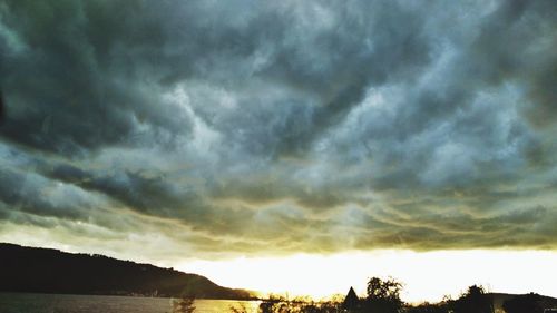 Silhouette of trees against cloudy sky