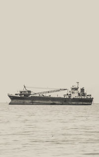 Ship sailing in sea against clear sky