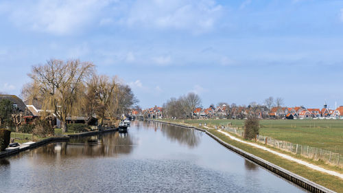 River amidst trees and buildings against sky