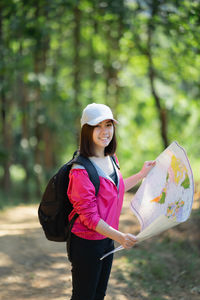 Young woman holding umbrella while standing on land