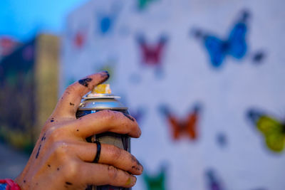 Cropped hand of woman making graffiti on wall