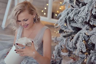 Beautiful young woman in christmas tree during winter