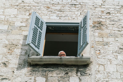 Low angle view of man on building wall