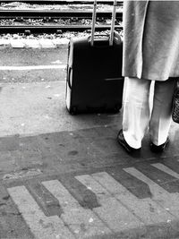 Low section of man standing on railroad track