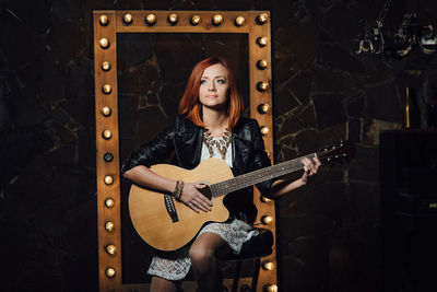 Portrait of young woman with guitar