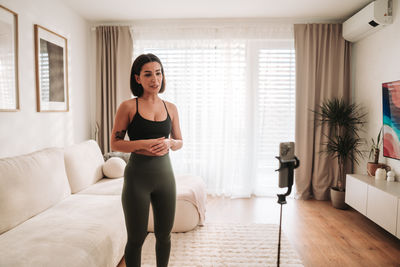 Portrait of young woman exercising at home