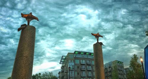 Low angle view of buildings against cloudy sky