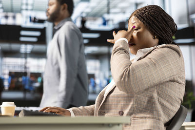 Side view of young man using mobile phone in office