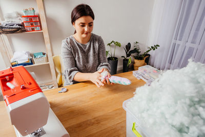 Portrait of young woman sitting on table at home