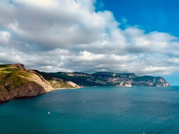 Scenic view of sea and mountains against sky