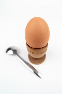 Close-up of egg in glass against white background