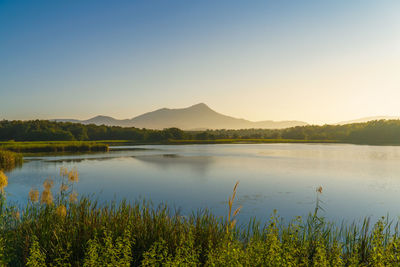 Scenic view of lake against clear sky during sunset