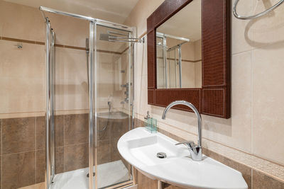 Interior of a new luxury bathroom with a mirror in a leather frame.