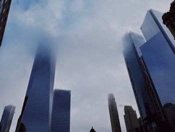 Low angle view of buildings against cloudy sky