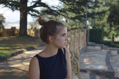 Teenage girl looking away while standing outdoors