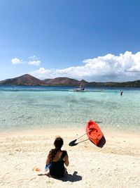 Rear view of women on beach against sky