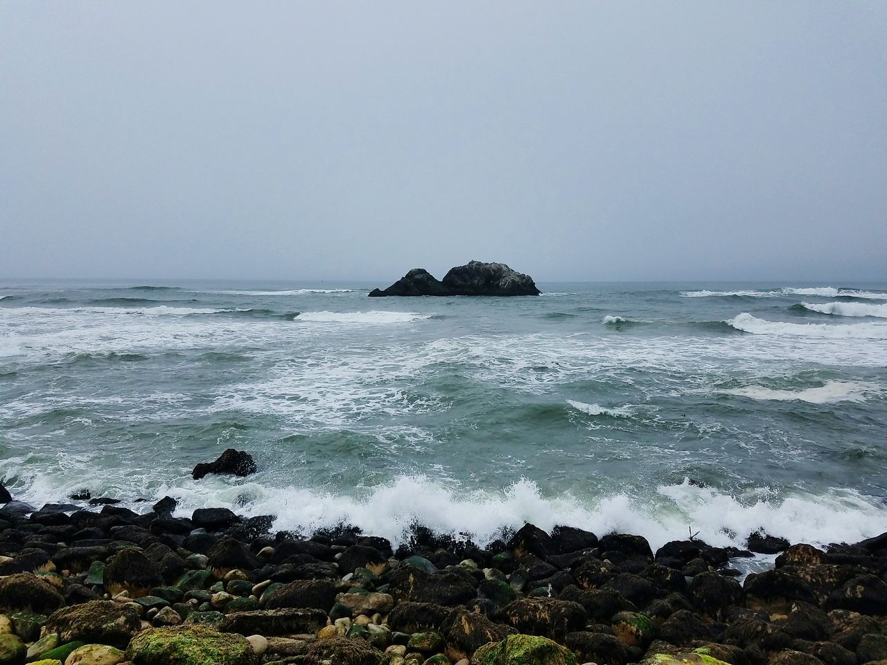 sea, horizon over water, water, clear sky, beach, scenics, tranquil scene, copy space, beauty in nature, tranquility, shore, wave, nature, rock - object, coastline, surf, idyllic, seascape, rock formation, cliff