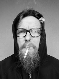 Portrait of man wearing eyeglasses against wall