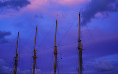 Low angle view of sailboat against a purple sky at sunset
