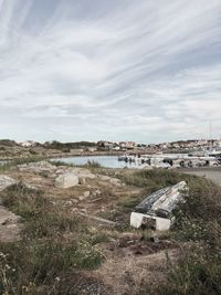 Scenic view of river by buildings against sky