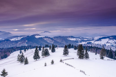 Scenic view of snow covered landscape against sky during sunset