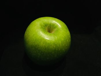 Close-up of apple on table against black background