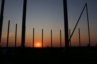 Scenic view of silhouette field against orange sky