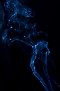 Close-up of blue smoke against black background