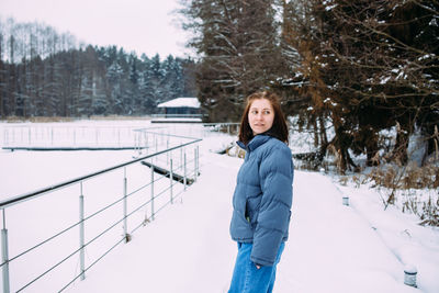 Portrait of young woman standing on snow