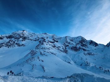 Scenic view of snowcapped mountains against blue sky