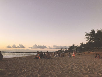 People on beach against clear sky