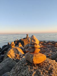 Stacked stones on the beach with a beautiful sunset light shining on them. 