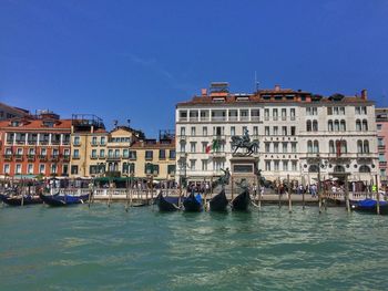 Boats in canal against buildings in city