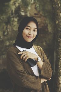 Portrait of smiling young woman standing outdoors