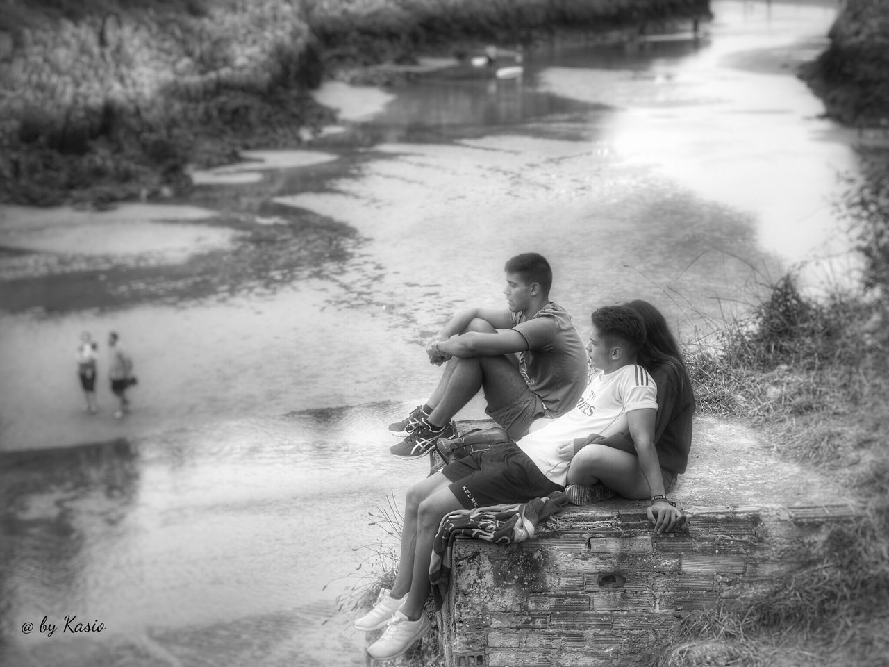 TWO PEOPLE SITTING ON BEACH