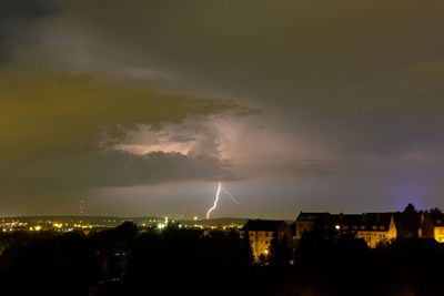 Lightning over illuminated city at night