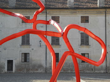 Close-up of red metal hanging on building