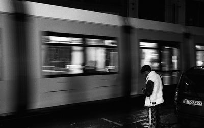 Rear view of woman standing on train at railroad station