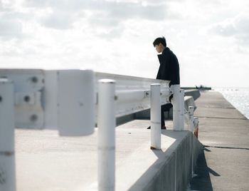 Full length of man on railing against sky