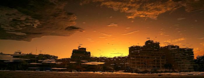 Buildings in city against sky during sunset