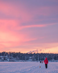 Rear view of woman standing on snow covered landscape