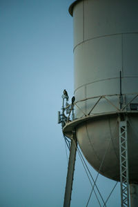 Low angle view of communications tower against sky