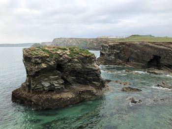 Rock formation in sea against sky