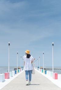 The back of woman walking on the rainbow bridge to see the viewpoint at the samut sakorn province, 