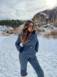 Young woman standing on snow covered field