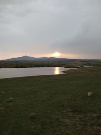 Scenic view of field against sky during sunset