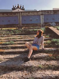 Full length of woman sitting outdoors
